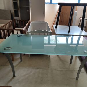 Masă modernă cu blat de sticlă mată și picioare metalice curbate